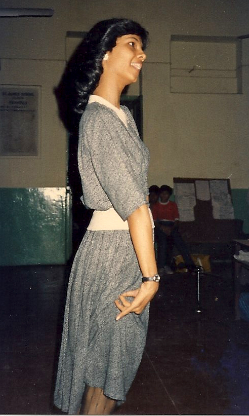 A young girl on profile wearing a black and white dress.